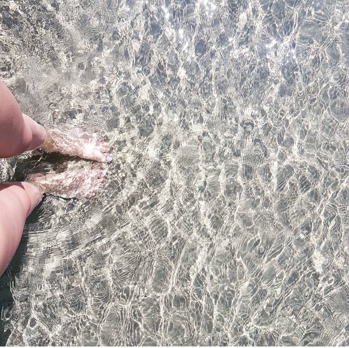 Feet in the clear crystalline water of the Aegean Sea
